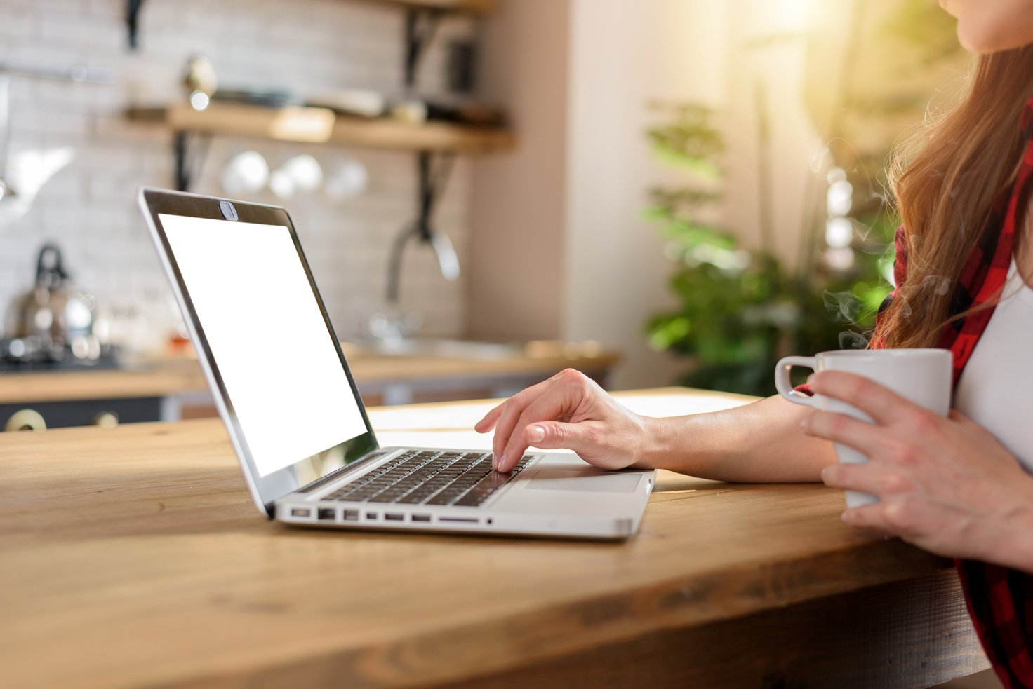 Woman Surfs in Internet with Her Laptop with a White Screen. She Work at Home as Smart Working